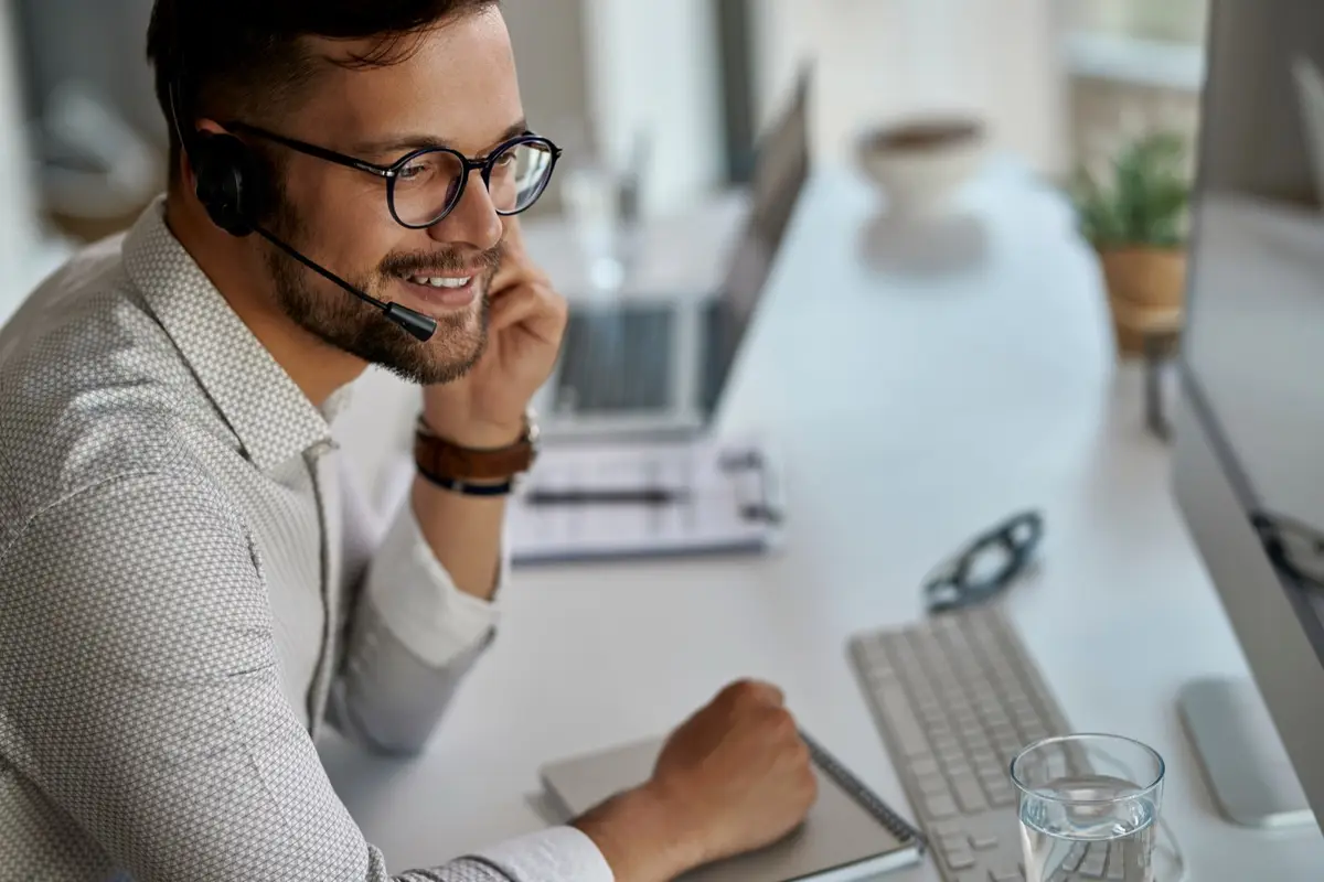 Call center agent with a headset working at a computer