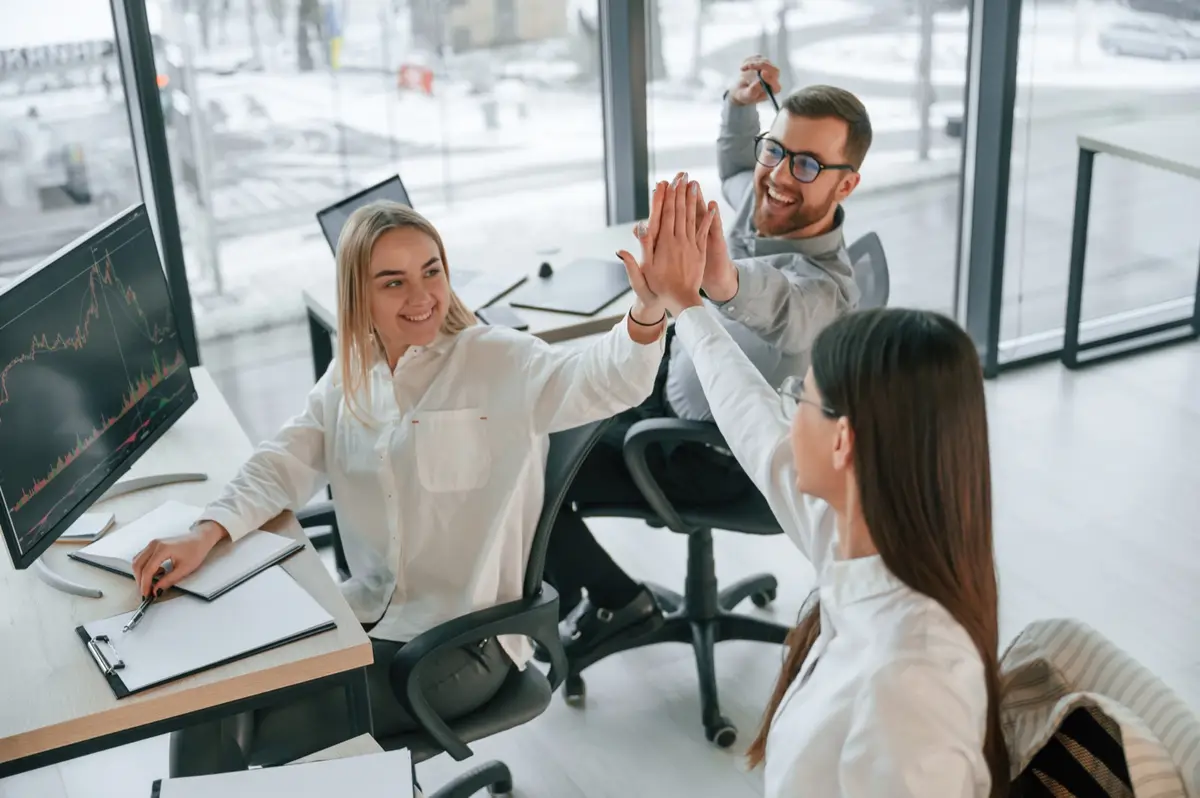 Colleagues celebrating with a high five in the office